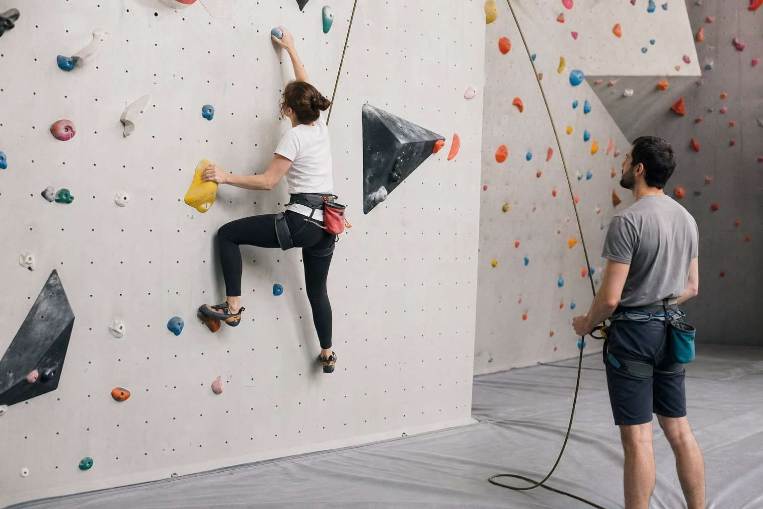 Miedo a las alturas en escalada y montaña: cómo avanzar sin forzarte — Imagen 1 Principiante practicando escalada a poca altura con supervisión